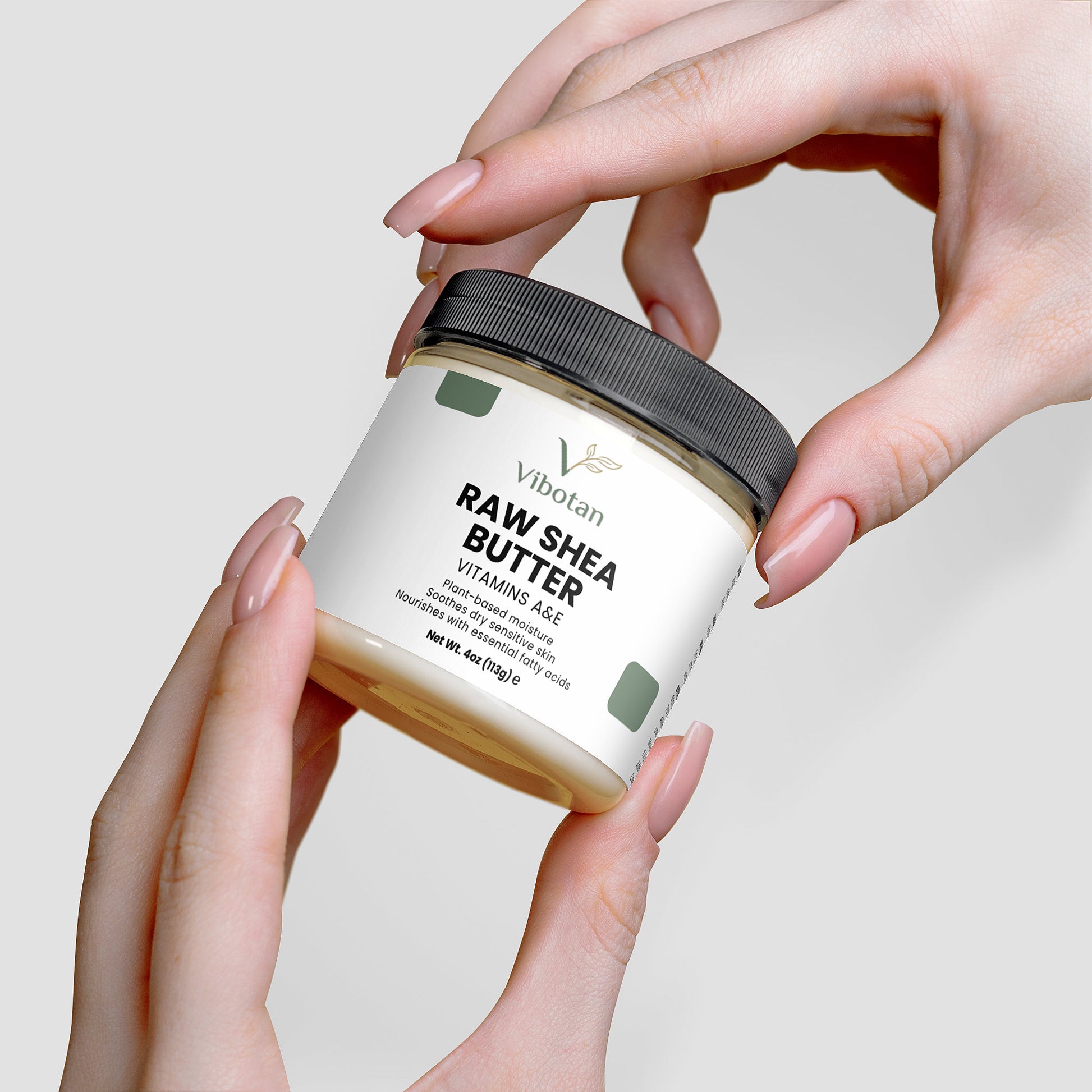 Jar of Vilbotan Raw Shea Butter held by hands against a neutral background