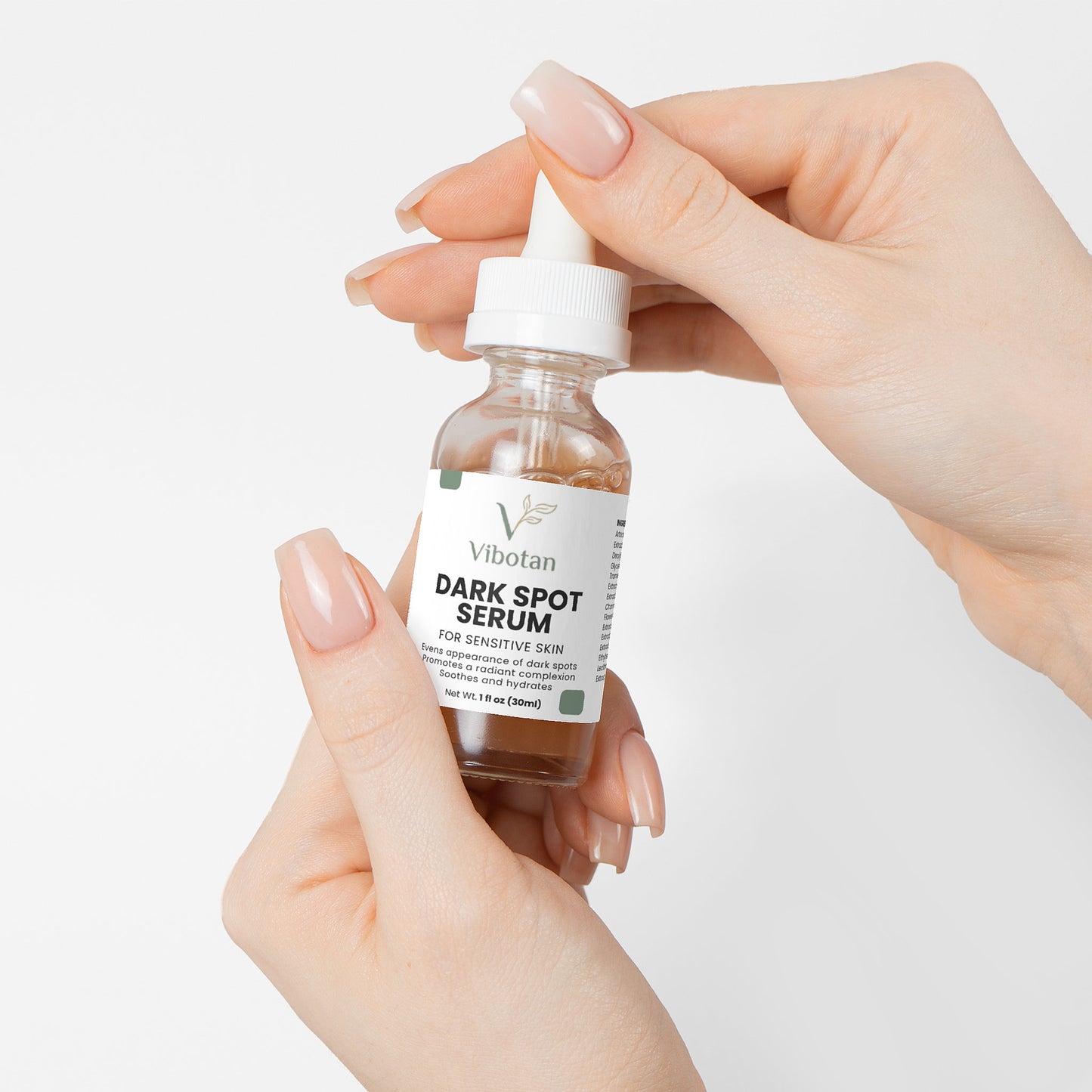 Hand holding a bottle of Soluna Dark Spot Serum against a white background