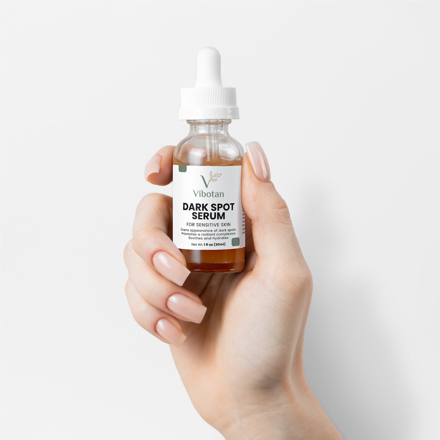 Hand holding a bottle of NaturaVital Dark Spot Serum against a white background