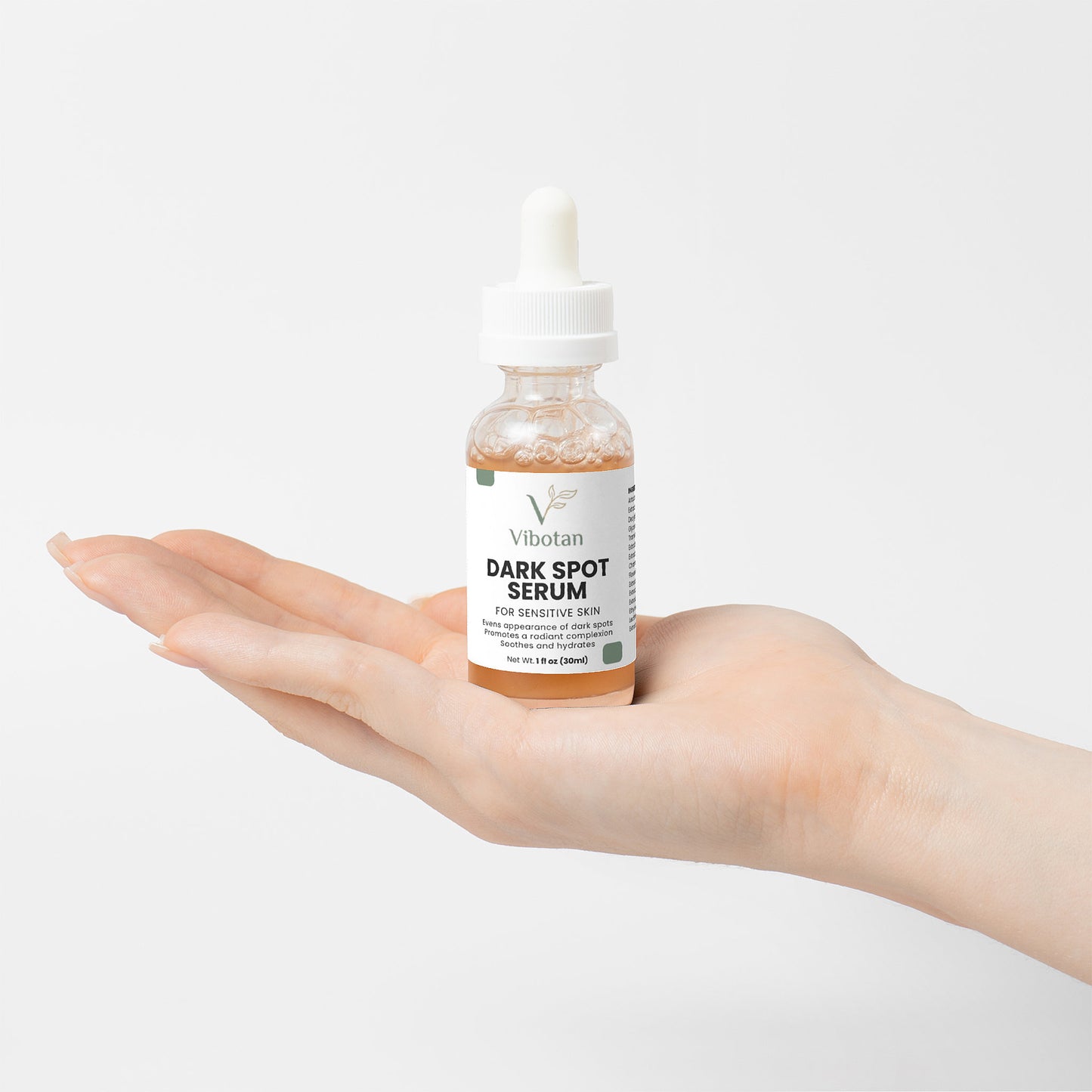 Vibotan Dark Spot Serum bottle held in a hand on a light background