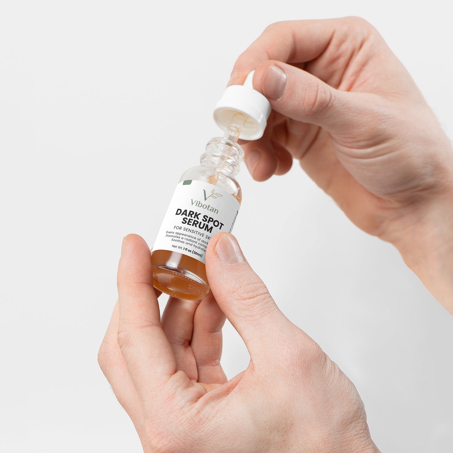 Hand holding a dropper bottle of A. Soluna Dark Spot Serum against a light background